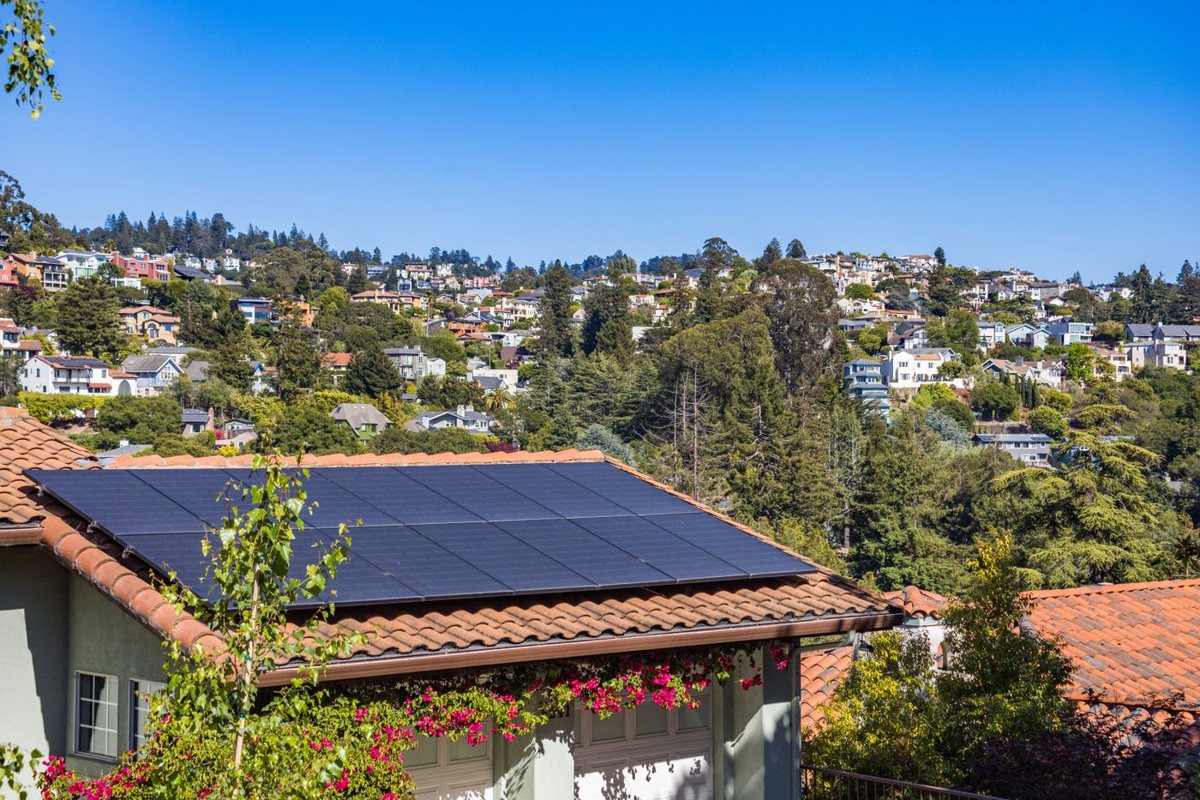 Solar panels installed on the tiled roof of a suburban home.